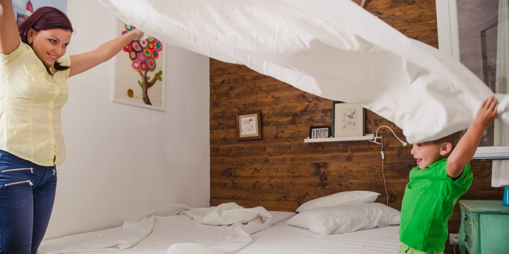 Personnes qui changent les draps et adhèrent une chambre