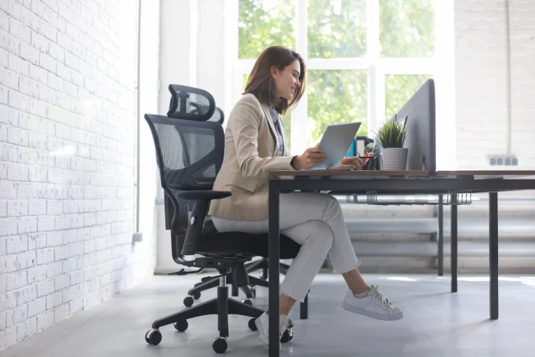 Une femme est assise sur une chaise ergonomique et design