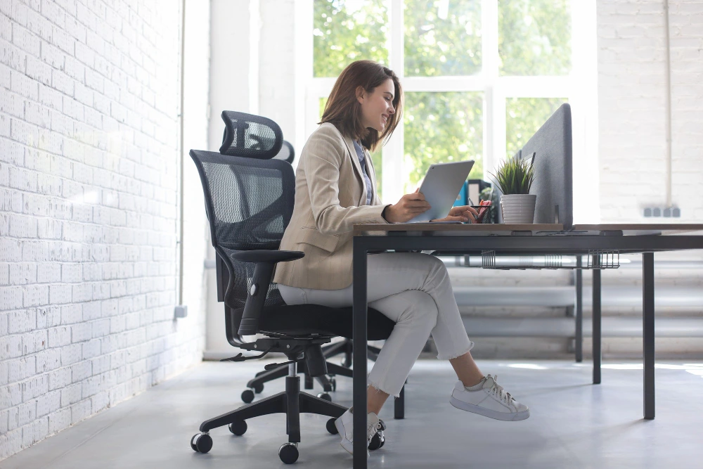 Une femme est assise sur une chaise ergonomique et design