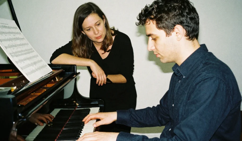 Un homme de 45 ans apprenant à jouer du piano avec sa professeure