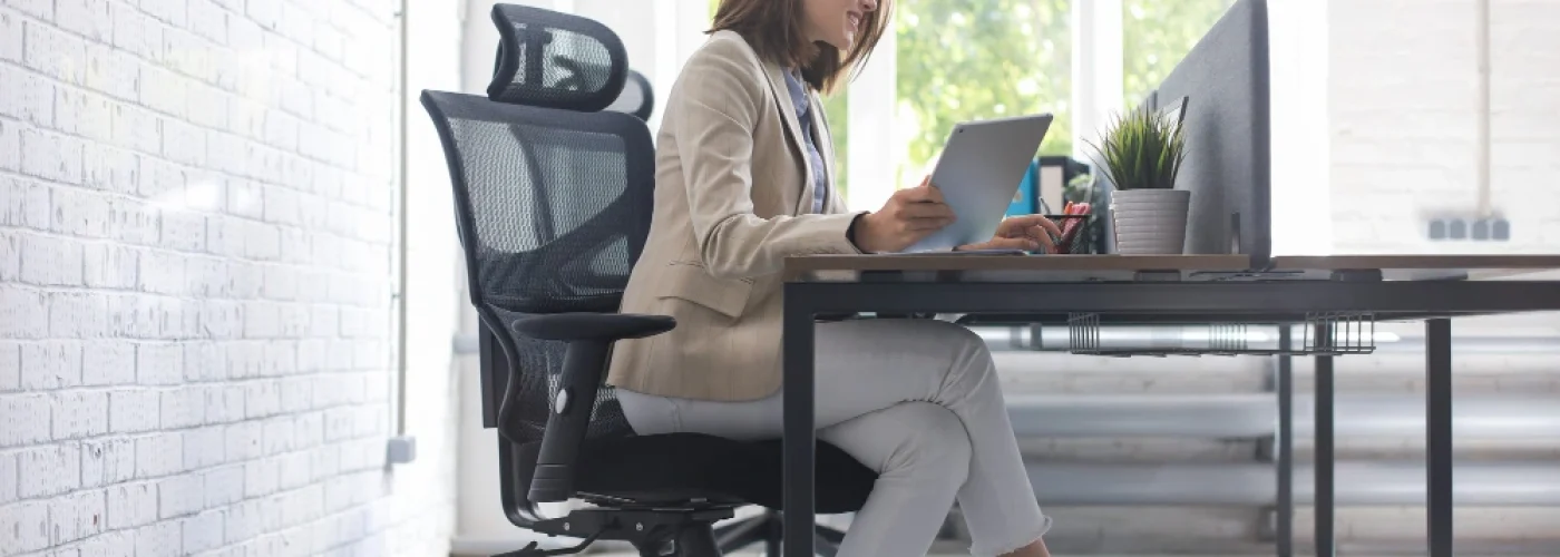 Une femme est assise sur une chaise ergonomique et design
